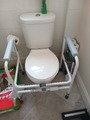 Toilet frame with handles placed over toilet